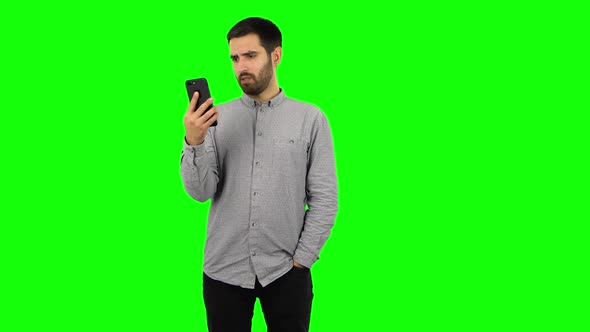 Brunette Guy Is Angrily Talking for Video Chat Using Mobile Phone. Green Screen