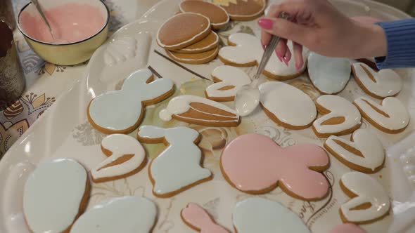 Decorating freshly-baked cookies with white cream. Confectioner squeezes icing from a pastry bag