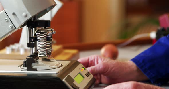 Horologist placing a watch on a machine