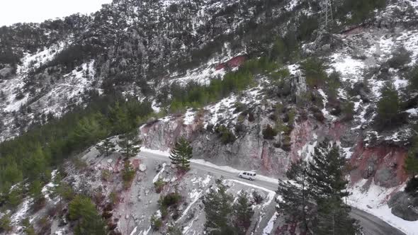 Car driving through scenic switchback road running through idyllic green wood