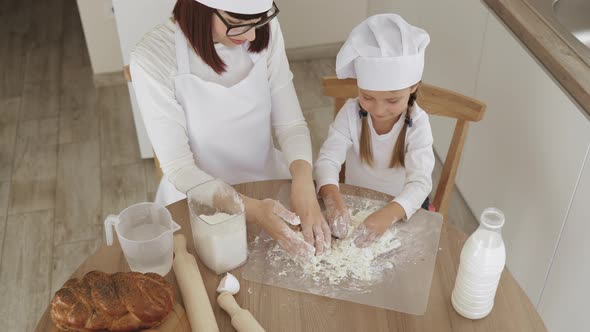 Cute Small Caucasian Child Daughter Helping Mother Kneading Preparing Dough