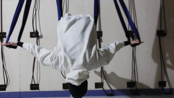 A Young Woman in Hijab and White Hoodie Does Aerial Yoga