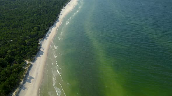 Tilt up from the turquoise tropical Osetnik beach waters with white sand to the sky, Poland