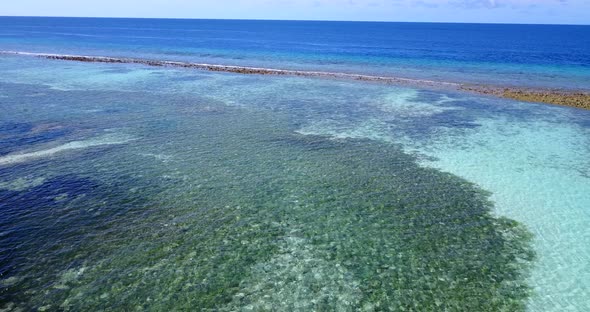 Daytime overhead travel shot of a white sandy paradise beach and blue ocean background in hi res 4K