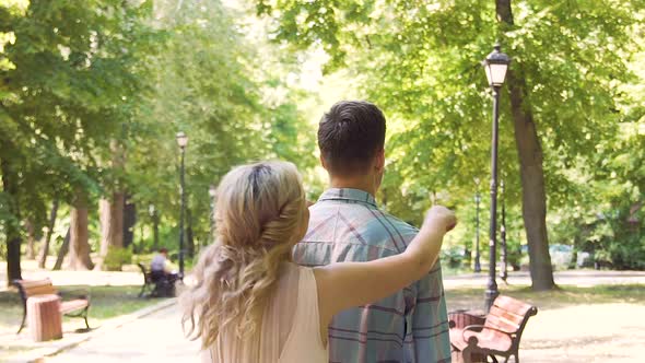 Beautiful young blonde jumping on boyfriends back by surprise, couple laughing