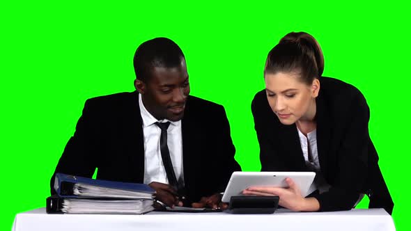 Business People Examining a Document in Their Office with a Laptop