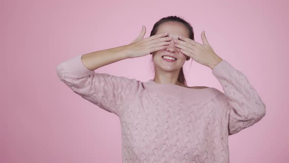 Funny Young Cheerful Woman Closes Her Eyes with Her Hands and Smiles