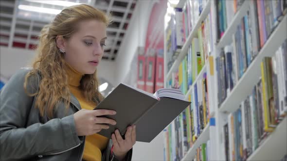 Portrait of a Young Beautiful Woman with Bright Red Hair in Glasses, Pretty Girl Reading in Book