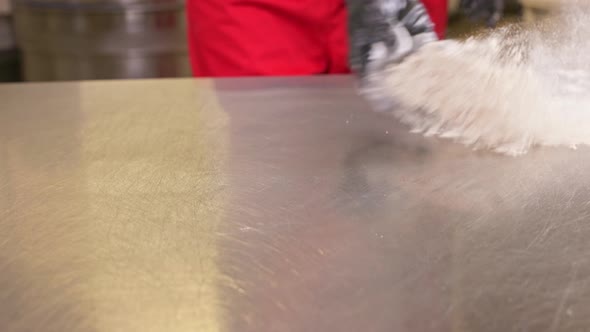 The Baker Pours Flour on the Table