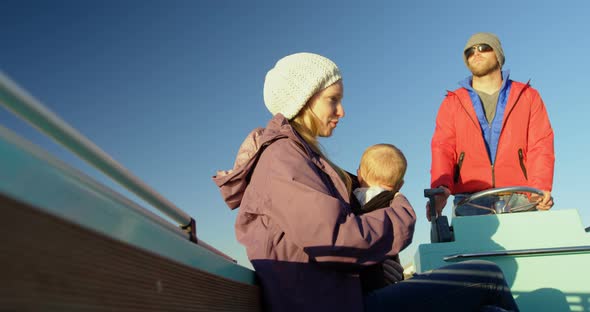 Parents with baby travelling in motorboat 4k