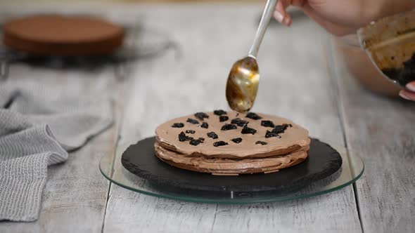 Step by step. Pastry chef making chocolate layer cake with prune filling