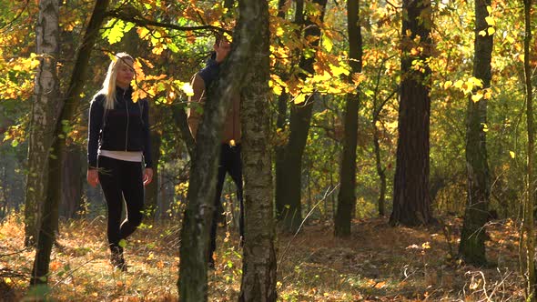 A Hiking Couple Walks Through a Forest on a Sunny Day