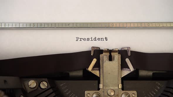 Typing word President on retro typewriter. Close up.