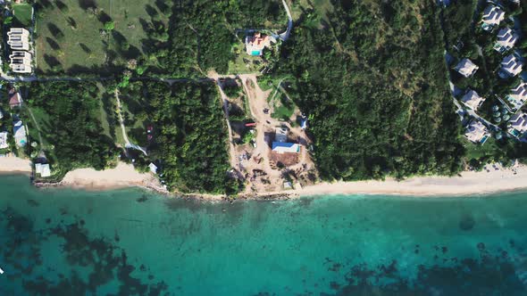 Top-down view of dense forest and rooftops on the seashore in Saint Kitts and Nevis