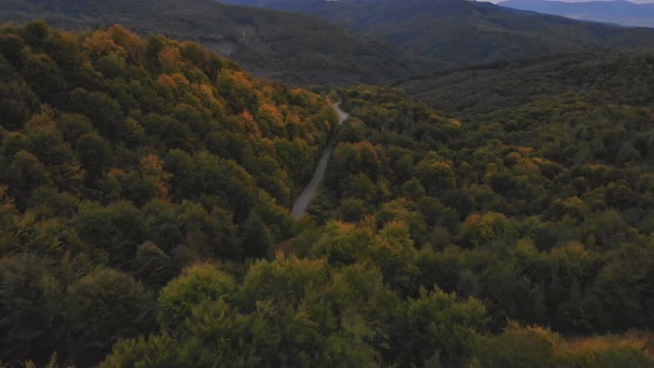 Flight Over Autumn Mountains with Forests Meadows and Hills in Sunset Soft Light