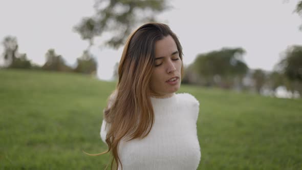 Close Portrait Shot of Young Woman Outdoors Stretching Back and Neck