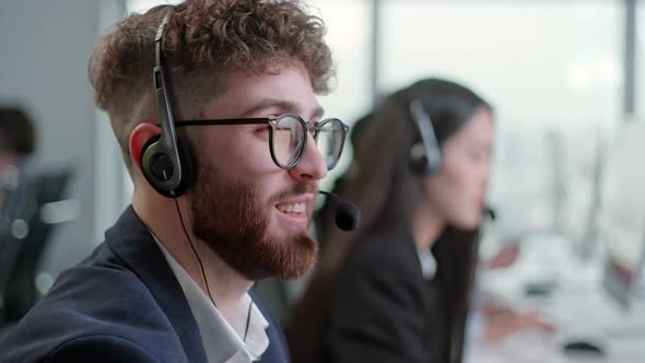 Close Up Portrait of a Technical Customer Support Specialist Talking on a Headset While Working on a