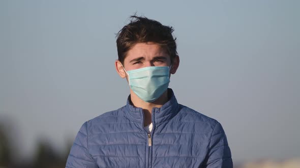 Portrait Man Wearing Protective Face Mask Look at Camera Touches the Hair COVID-19 Coronavirus