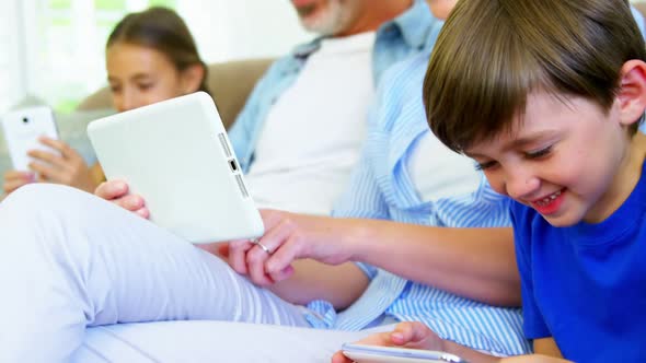 Boy sitting with family using mobile phone