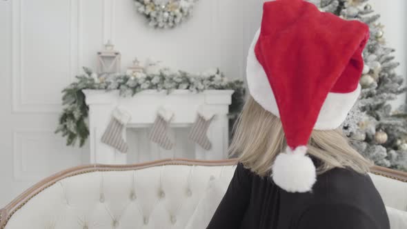 Close-up of Beautiful Caucasian Woman in Red Hat Putting on Yellow Garland, Looking Back at