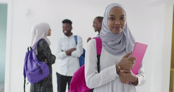 African Female Student with Group of Friends in Background Wearing Traditional Islamic Hijab Clothes