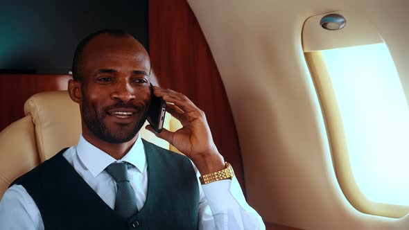 Successful entrepreneur talking on the phone on his private jet