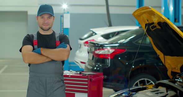 Portrait of a Car Mechanic at Work at the Car Repair Shop, Smiling Man at Factory Warehouse.