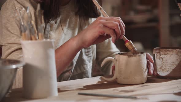 Young Woman Potter Working in Art Studio  Painting the Final Ceramic Product From the Inside