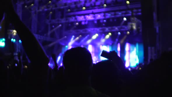 Silhouettes of Many People Applauding and Filming Video on Phone at Concert