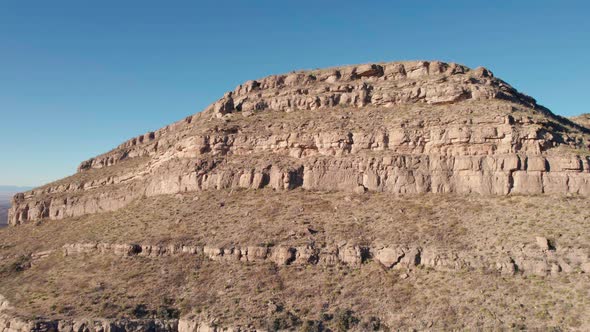 Drone aerial fly-by of a large cliff face with layers of rock and washout