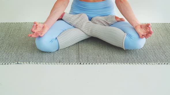 Young woman in a lotus pose on meditation close up, lifestyle concept