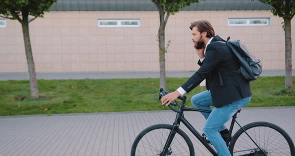 Office Manager in Stylish Clothes which Riding on Bike Simultaneously Talking on Phone