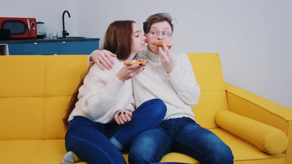 a Young Loving Couple Spend Time Together at Home Eating Pizza and Laughing