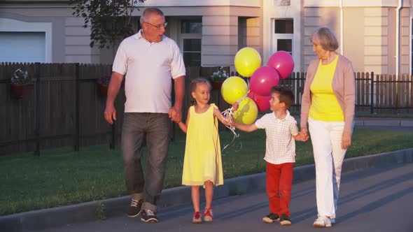 Happy Kids Walking With Grandparents