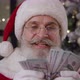 Closeup Portrait of a Cheerful Santa Claus Rejoicing Counting Paper Banknotes in His Residence - VideoHive Item for Sale