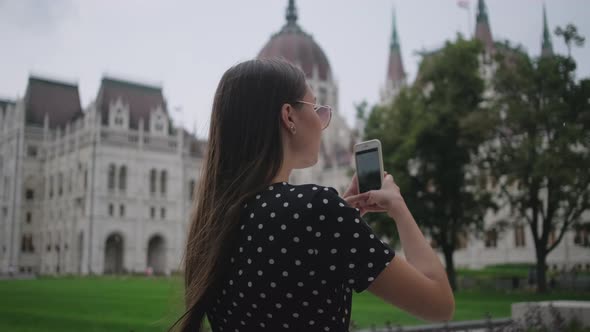 Woman is Taking Picture By Mobile Phone of Hungarian Parliament Building