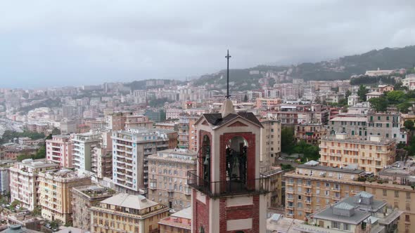 Belltower and city skyline of Genoa, aerial drone orbit view