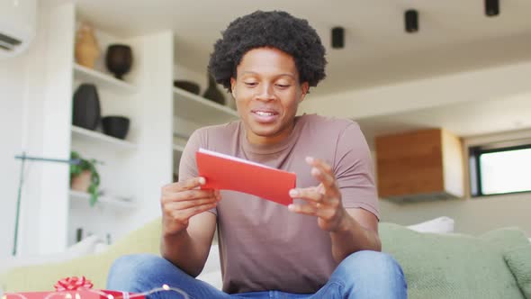 African american man opening gift at home