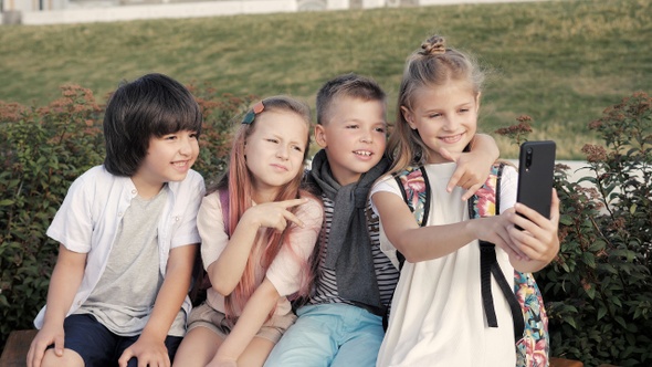 Little kids making faces while. taking selfie.