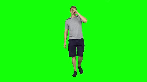 Young Man Walking and Watching on the Phone Something, Drinking Coffee. Chroma Key