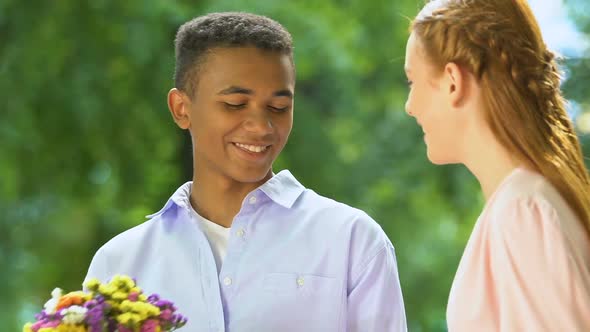 Black Teenage Boy Giving Wildflowers to Caucasian Girl, Multiethnic Relations