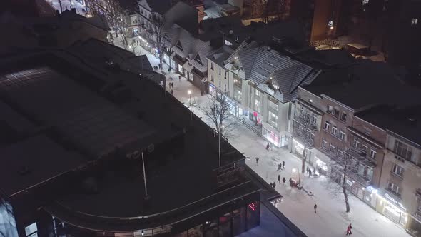 Aerial forward over Zakopane Krupowki main street in wintertime at night with snow. Poland