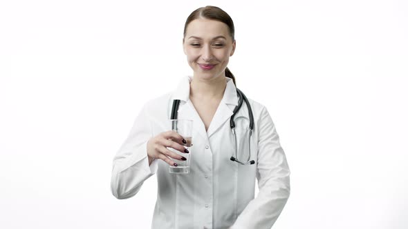 Young Female Doctor Holds Glass of Clean Water and Shows Like Sign with Thumb Up