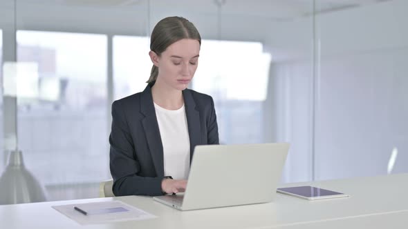 Ambitious Young Businesswoman Working on Laptop in Office