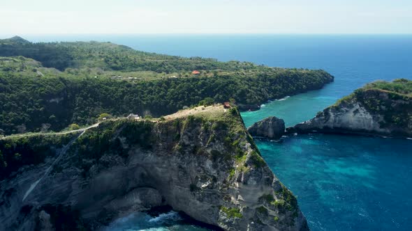 Fly around cliff and rocks over ocean along coast