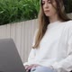 Young Female in Garden Using Laptop Communicates on Internet with Customer - VideoHive Item for Sale