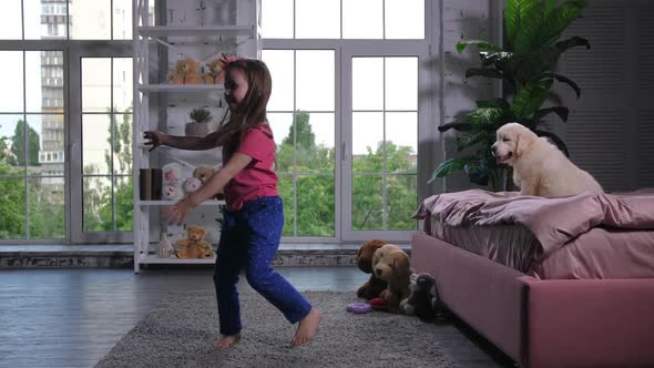 Graceful Child Dancing for Puppy Sitting on Bed