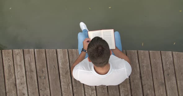 Reading a Book on a Pier