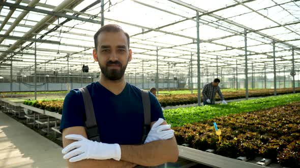 Smiling Young Agronomist in a Greenhouse with Modern Technology