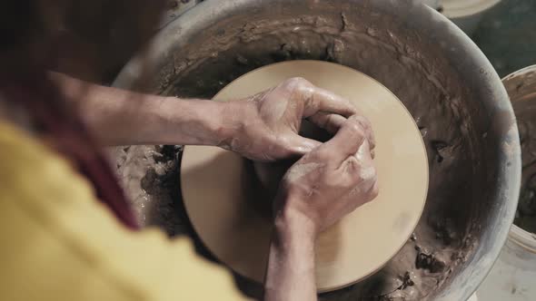 Hands of the Master Potter and Vase of Clay on the Potter's Wheel Closeup